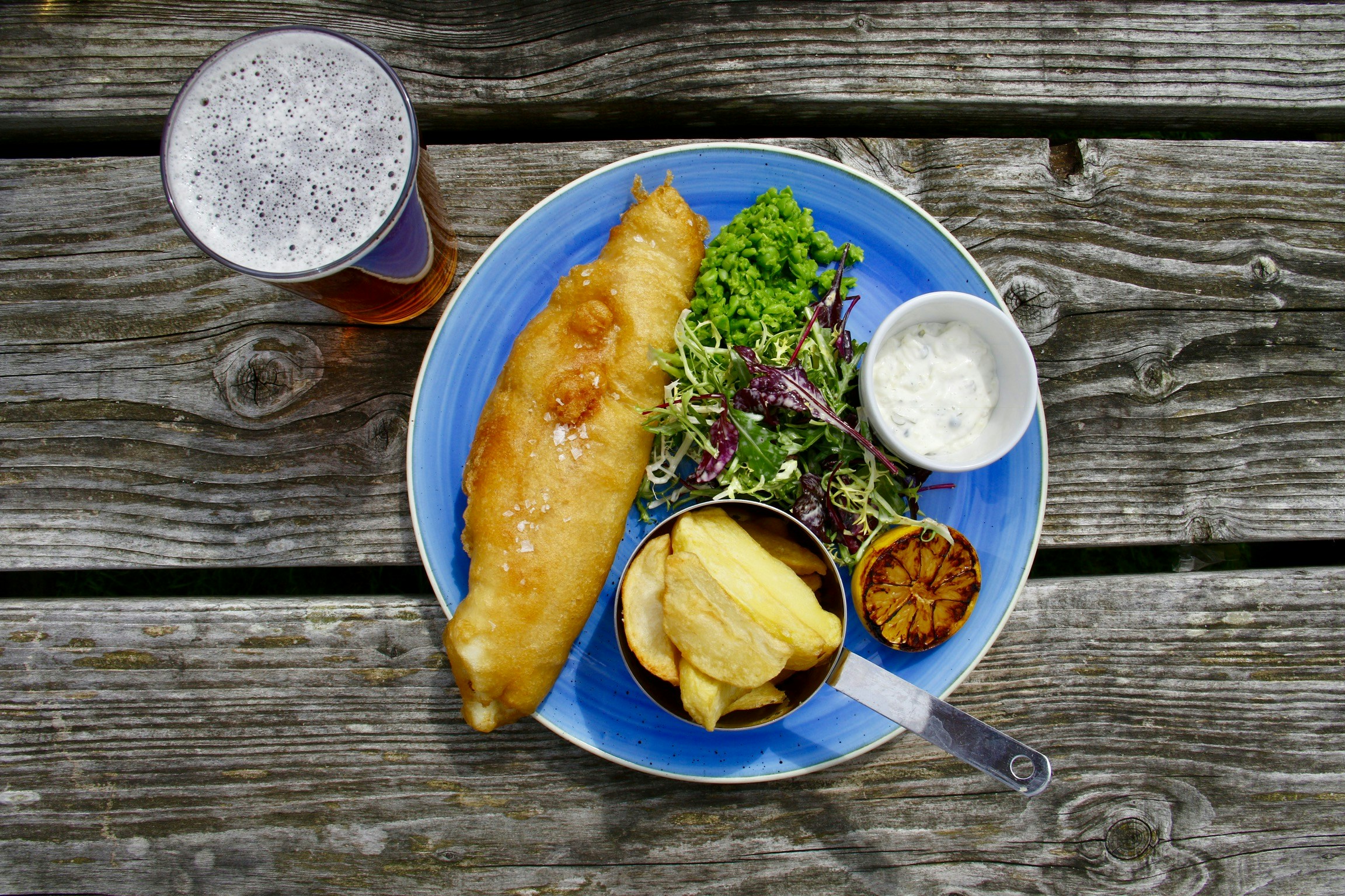 A portion of Fish and Chips served on a wooden table